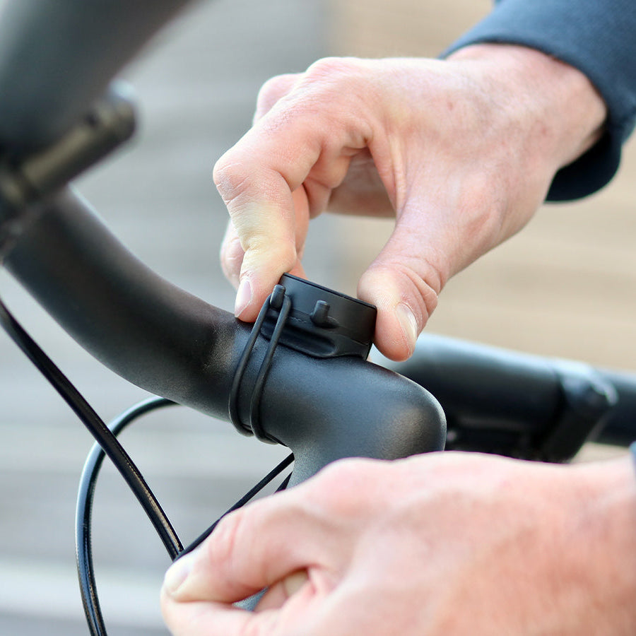 Installation du support sur un guidon vélo avec les 2 élastiques. Facilité et rapidité d'installation, les élastiques sont robustes et permettent un maintien parfait du téléphone
