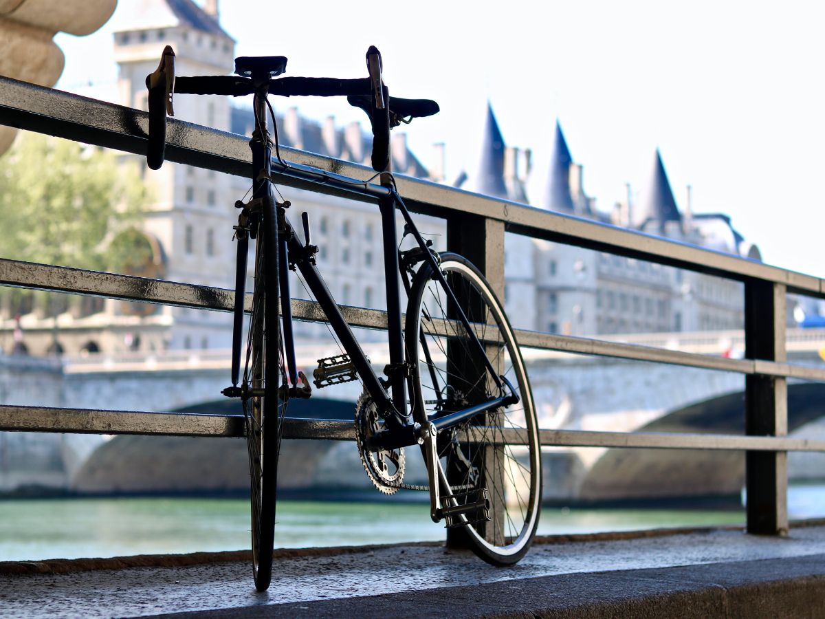 Vélo de route avec géométrie endurance posé sur une route de campagne, équipé de pneus larges et sacoches discrètes.