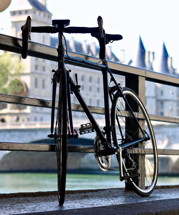 Vélo de route avec géométrie endurance posé sur une route de campagne, équipé de pneus larges et sacoches discrètes.