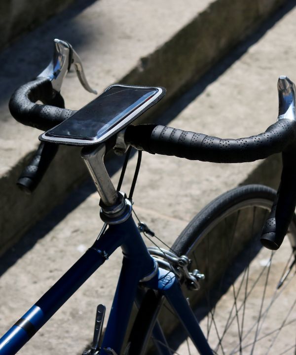 Support smartphone magnétique fixé sur le guidon d’un vélo de route, affichant une appli GPS en action.