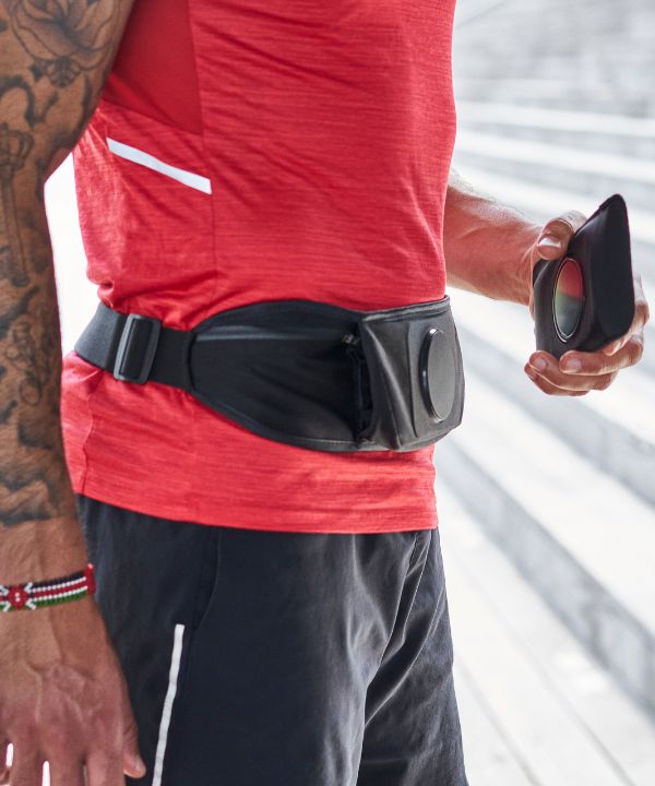 Coureur ajustant une ceinture porte-dossard avant une course officielle.