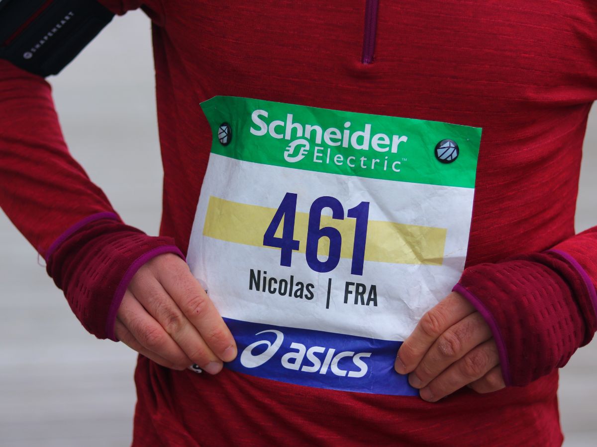 Coureur en action avec dossard bien centré et lisible sur le haut du ventre.