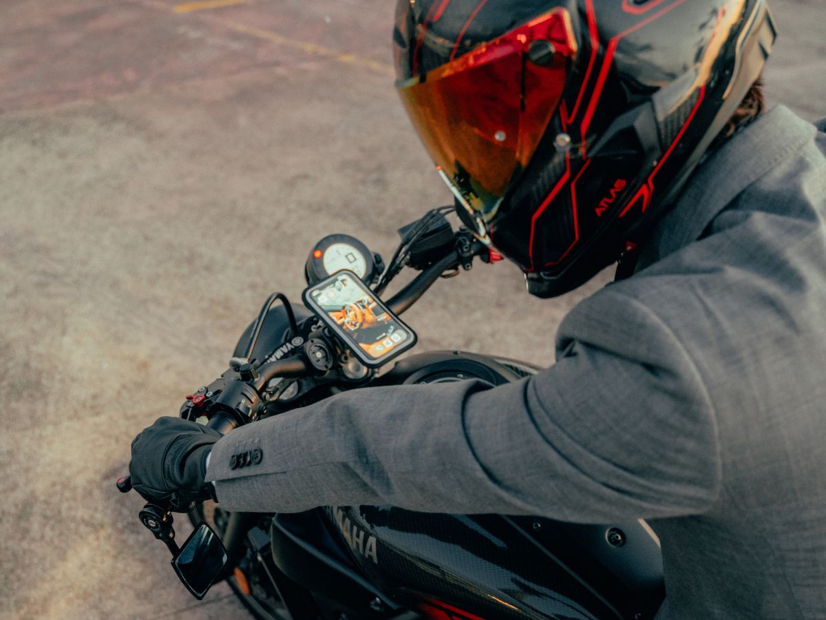 Contenu minimaliste d’un sac de motard : gants, antivol compact, powerbank.