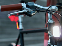 Lumière avant blanche Shapeheart fixée sur un vélo, assurant un éclairage puissant pour une conduite nocturne en toute sérénité.