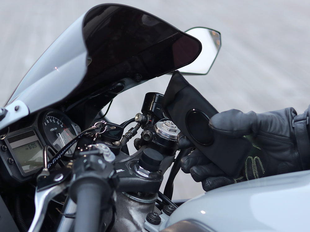 Support fixé sur demi-guidon moto sportive avec pochette tactile et étanche, maintien magnétique sécurisé, angle de vue ajustable.